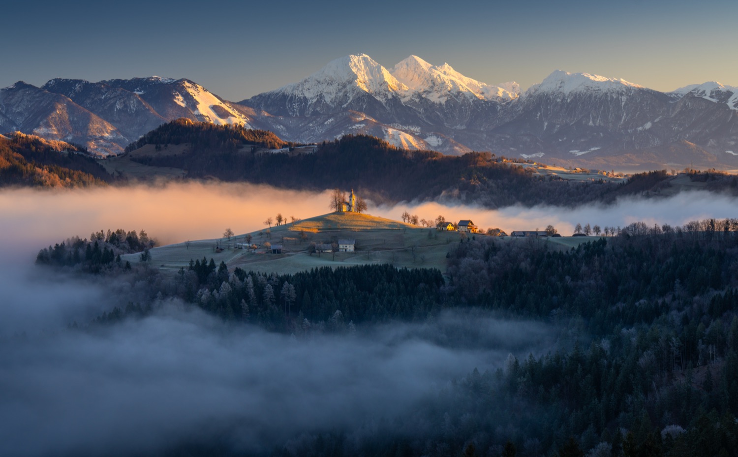 Slovenia church on a hill in fog